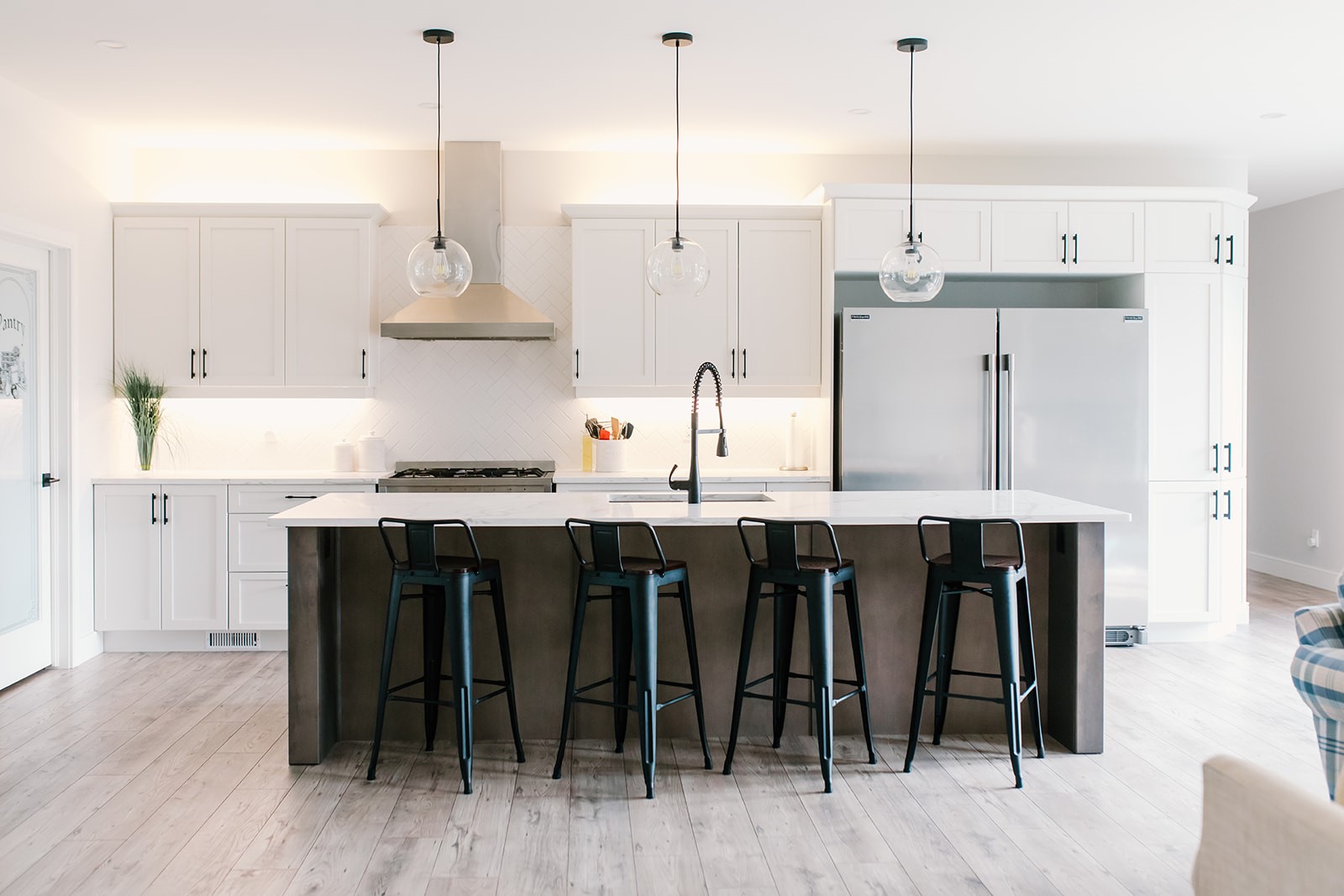 White shaker kitchen with dark wood island by TCM